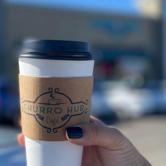 Churro Hub Cafe coffee cup in hand.