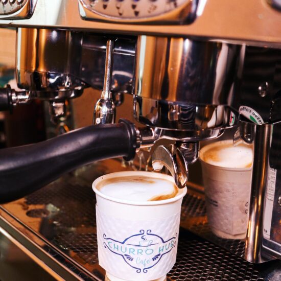 Espresso machine making coffee in cup.