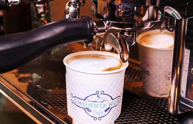 Espresso pouring into coffee cup.